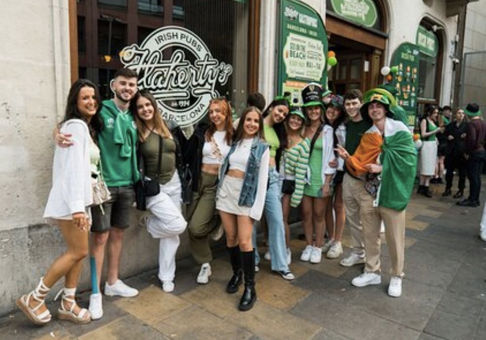 people standing outside of an Irish pub dressed in green